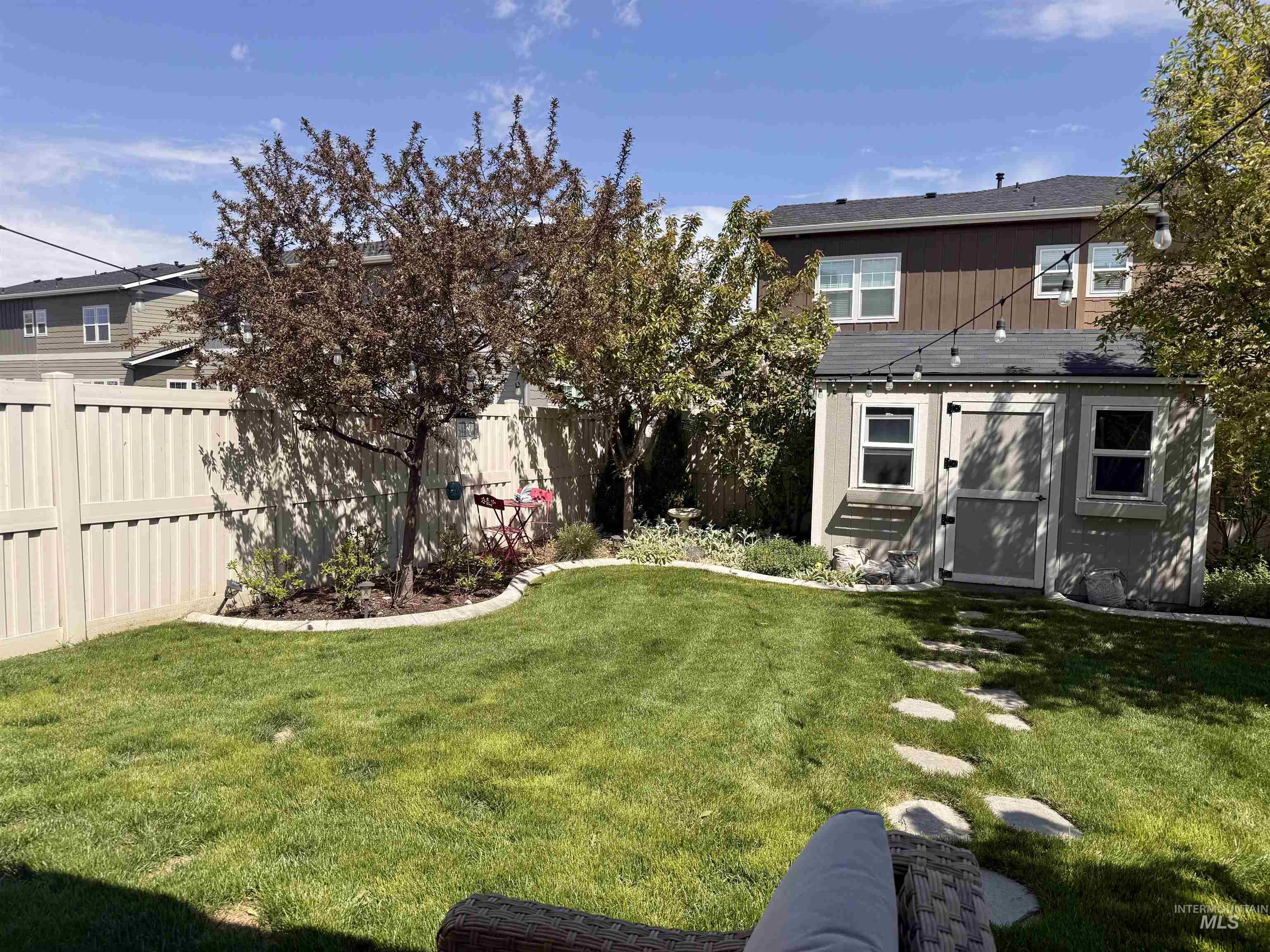 13314 Bloomfield Drive Caldwell, ID 83607 - Photo 20 of 32 Expansive backyard featuring a manicured lawn, established trees, and a beige privacy fence