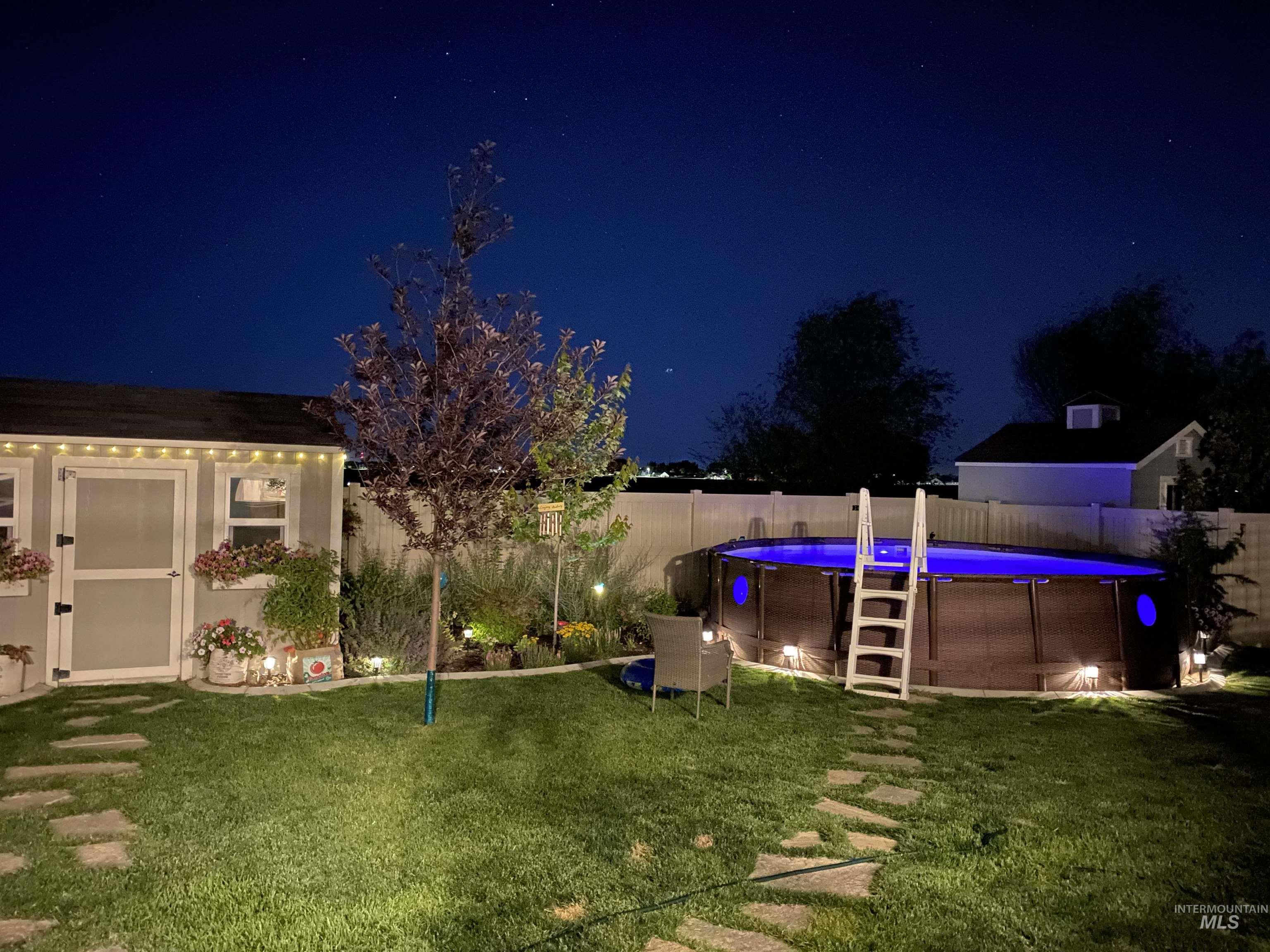 13314 Bloomfield Drive Caldwell, ID 83607 - Photo 25 of 32 Pool at night with a fenced backyard and an outbuilding
