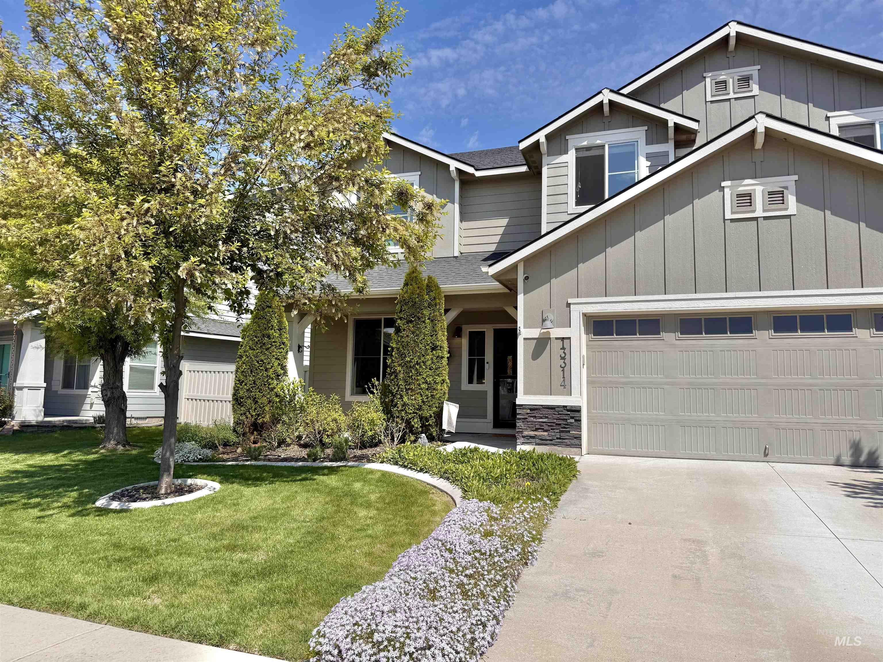 13314 Bloomfield Drive Caldwell, ID 83607 - Photo 31 of 32 Contemporary two-story residence featuring a two-car garage with transom windows, a concrete driveway, and an entryway with stone accent detailing