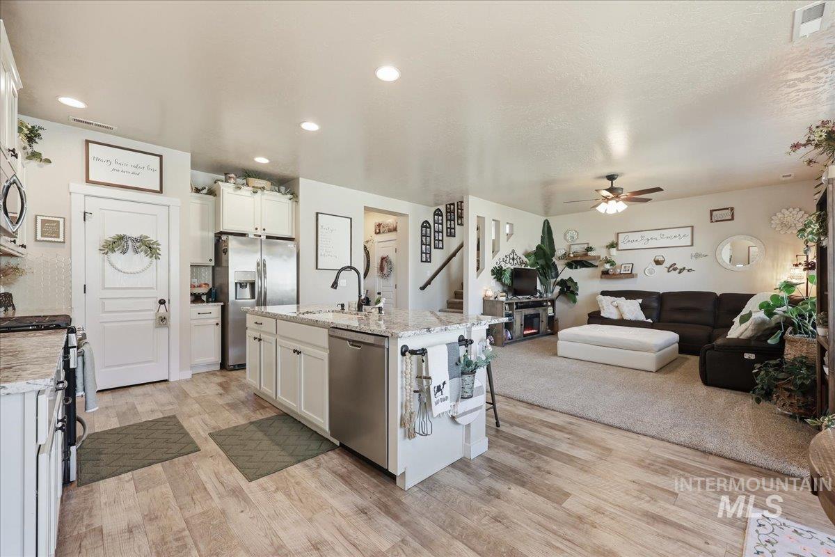 13314 Bloomfield Drive Caldwell, ID 83607 - Photo 32 of 32 Kitchen with an island with sink, open floor plan, light stone countertops, stainless steel appliances, and recessed lighting