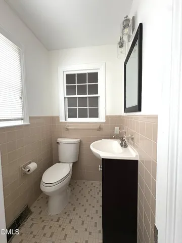 a bathroom with a granite countertop toilet a sink and a mirror