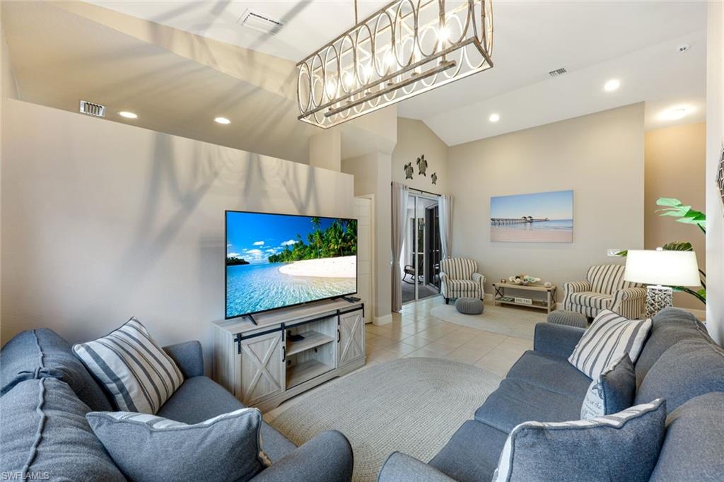 697 Crossfield Circle Naples, FL 34104 - Photo 5 of 18 Living area with light tile patterned floors, recessed lighting, a chandelier, and a towering ceiling