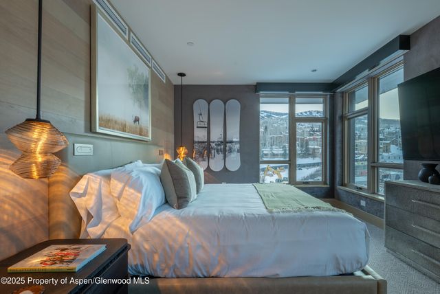 a bedroom with two beds and a flat tv screen on dresser