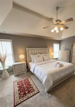 a bedroom with a large bed and a chandelier