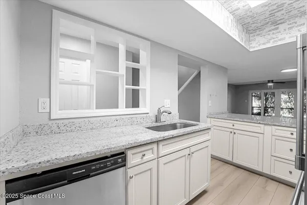a kitchen with granite countertop kitchen island white cabinets and white appliances