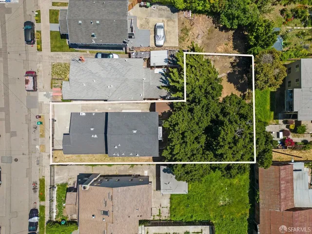 an aerial view of residential houses with outdoor space and street view
