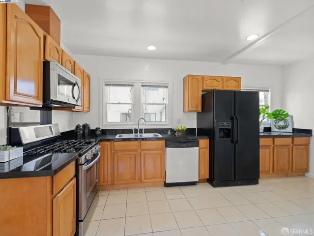 a kitchen with stainless steel appliances granite countertop a refrigerator and a stove top oven