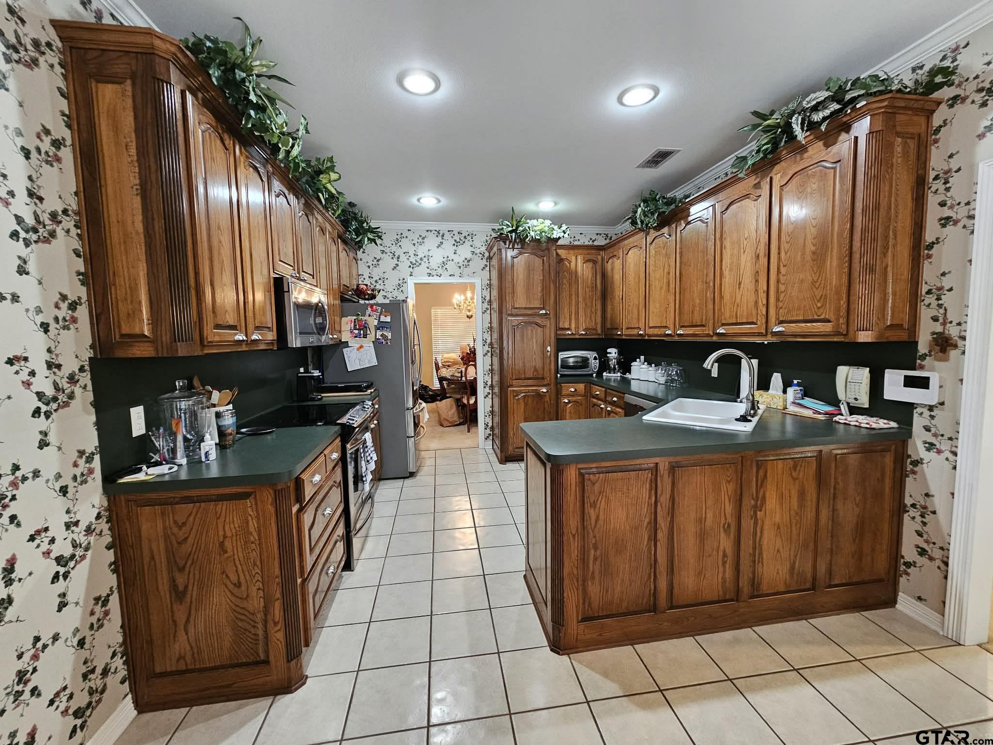 2001 Venture View Palestine, TX 75803 - Photo 4 of 28 a kitchen with stainless steel appliances granite countertop a refrigerator a sink and wooden cabinets