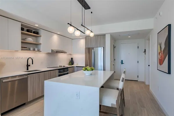 a kitchen with stainless steel appliances granite countertop a sink a stove and a refrigerator