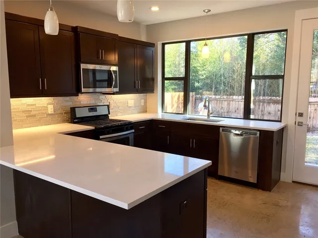 a kitchen with a sink a stove and microwave
