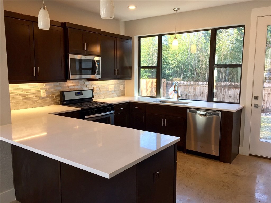 a kitchen with a sink a stove and microwave