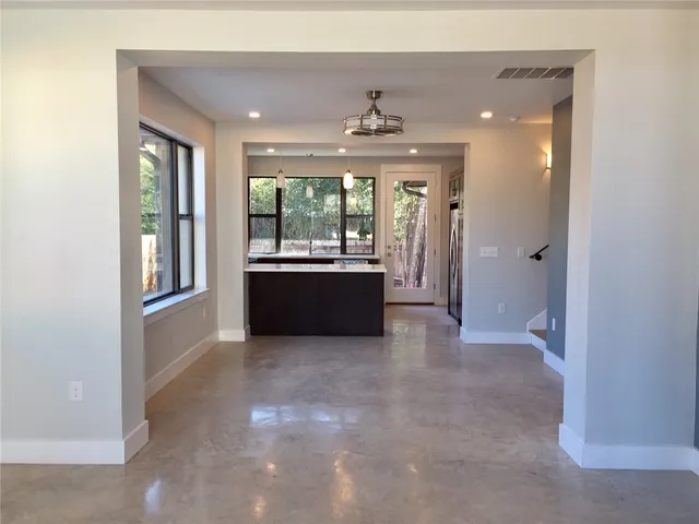 a view of a kitchen with large windows and kitchen view