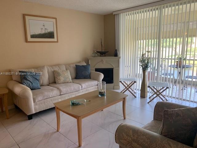 6021 Northwest 61st Avenue, Unit 208 Tamarac, FL 33319 - Photo 2 of 17 a living room with furniture and a floor to ceiling window