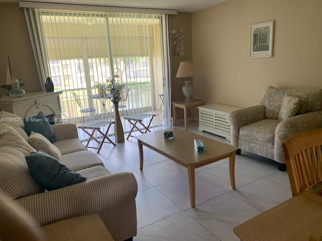 6021 Northwest 61st Avenue, Unit 208 Tamarac, FL 33319 - Photo 3 of 17 a living room with furniture and a table