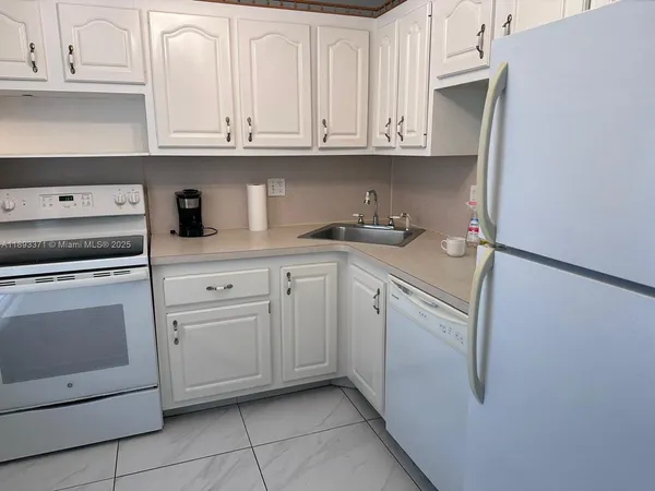 a kitchen with granite countertop white cabinets and stainless steel appliances