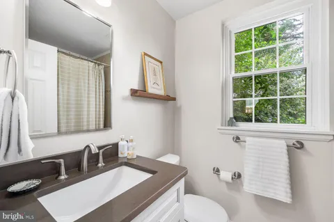 a bathroom with a sink vanity mirror and toilet