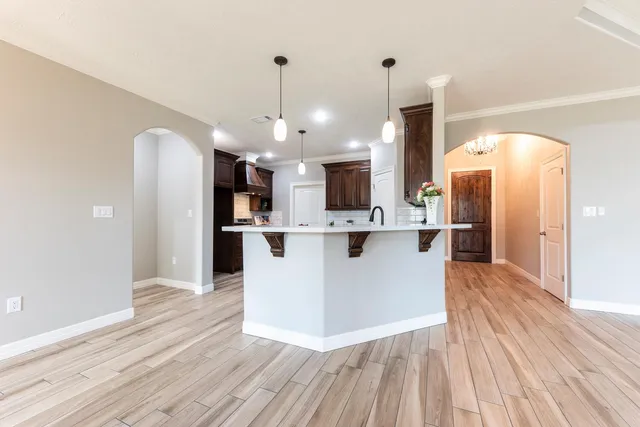 a view of a kitchen with cabinets stainless steel appliances and a chandelier