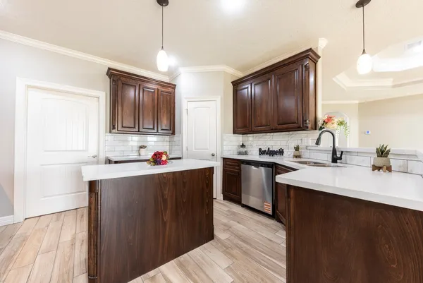 a kitchen with kitchen island granite countertop a sink appliances cabinets and furniture