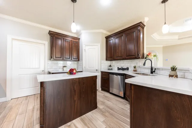 a kitchen with kitchen island granite countertop a sink appliances cabinets and furniture