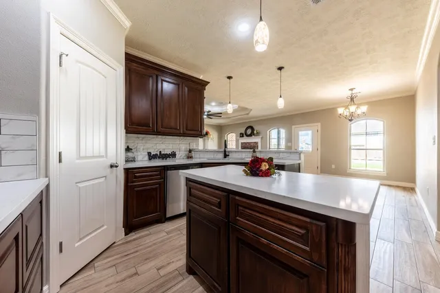 a kitchen with kitchen island granite countertop a stove cabinets and wooden floor