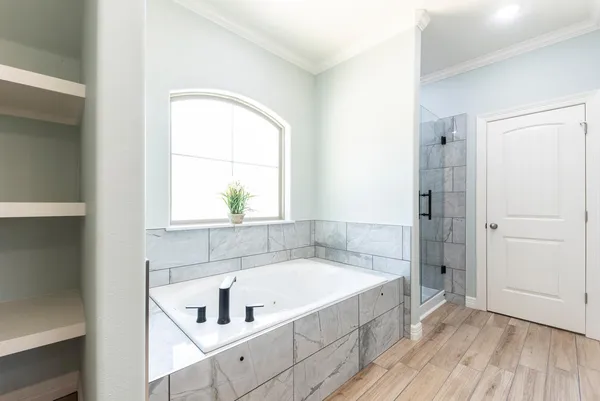 a bathroom with a tub a sink and a window