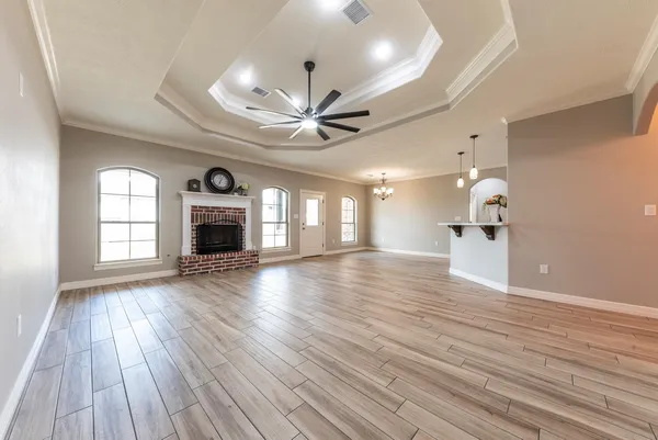 a view of empty room with wooden floor and fireplace