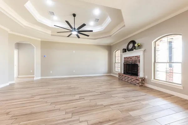 a view of an empty room with a fireplace and a window