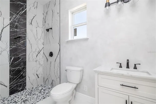 a bathroom with a toilet a sink and shower