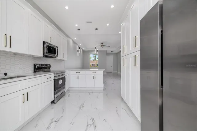 a kitchen with white cabinets and stainless steel appliances