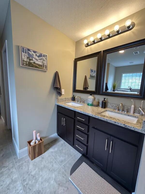 4716 Chanson Crossing Crestview, FL 32539 - Photo 9 of 16 a bathroom with a granite countertop sink mirror and vanity
