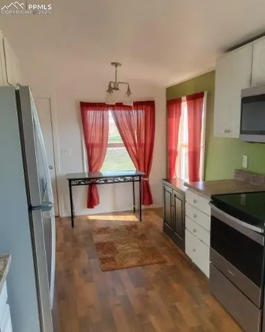a kitchen with stainless steel appliances granite countertop a refrigerator sink and wooden cabinets