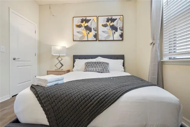 a bedroom with a bed and painting on the wall