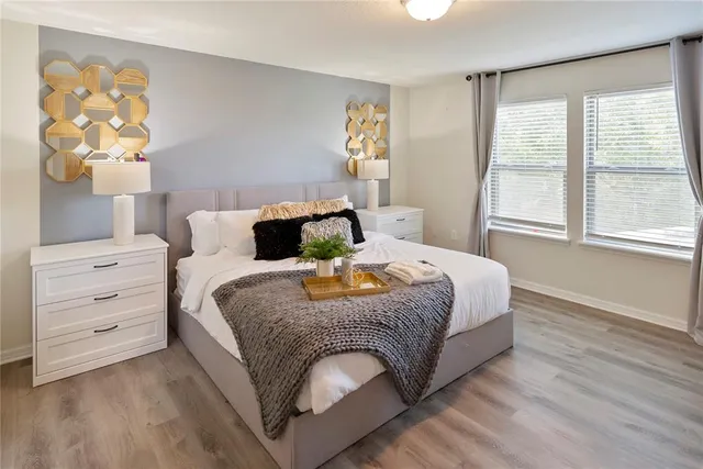 a bedroom with a bed and painting on the wall