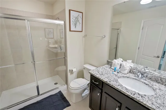 a bathroom with a granite countertop sink toilet and shower