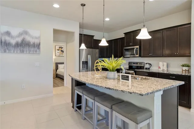 a kitchen with stainless steel appliances granite countertop a sink refrigerator and cabinets