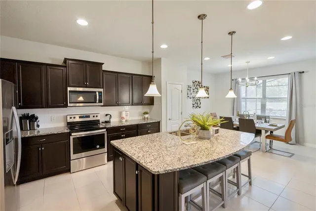 a kitchen with granite countertop stainless steel appliances and wooden floor