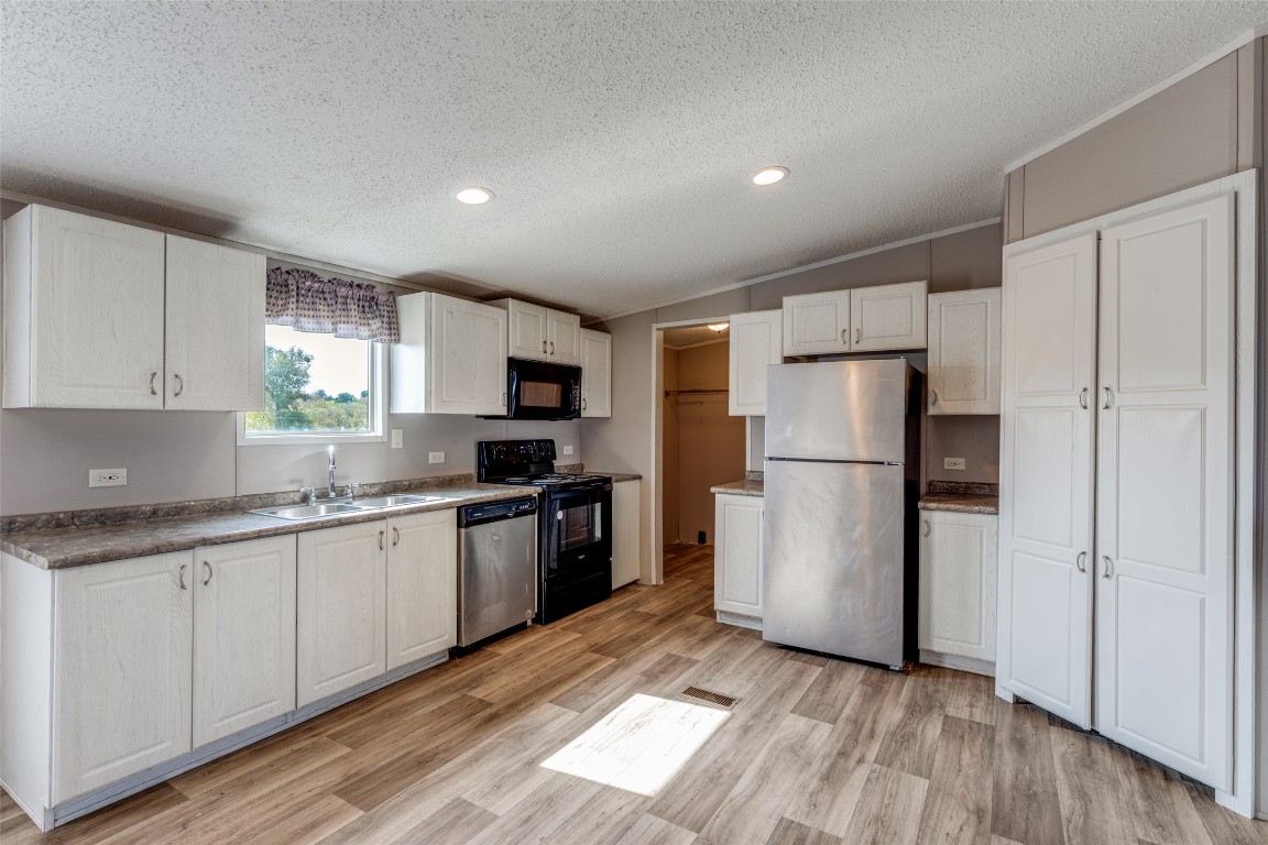 346 Rancho Linda Drive Lockhart, TX 78644 - Photo 11 of 25 a kitchen with a refrigerator a sink and cabinets