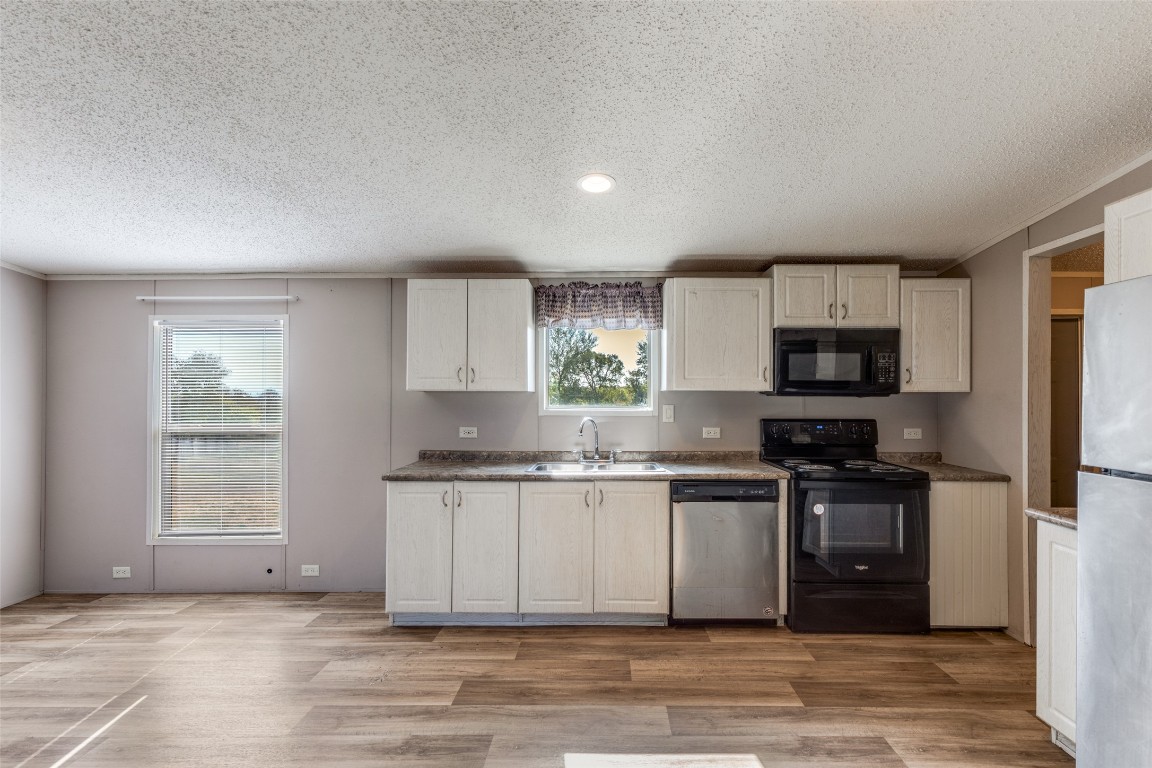 346 Rancho Linda Drive Lockhart, TX 78644 - Photo 12 of 25 a kitchen with stainless steel appliances granite countertop a stove a sink and a refrigerator