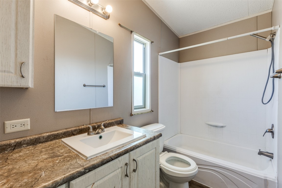346 Rancho Linda Drive Lockhart, TX 78644 - Photo 19 of 25 a bathroom with a granite countertop sink toilet a large mirror a shower and vanity
