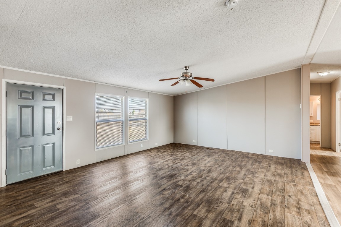 346 Rancho Linda Drive Lockhart, TX 78644 - Photo 4 of 25 an empty room with wooden floor chandelier fan and windows