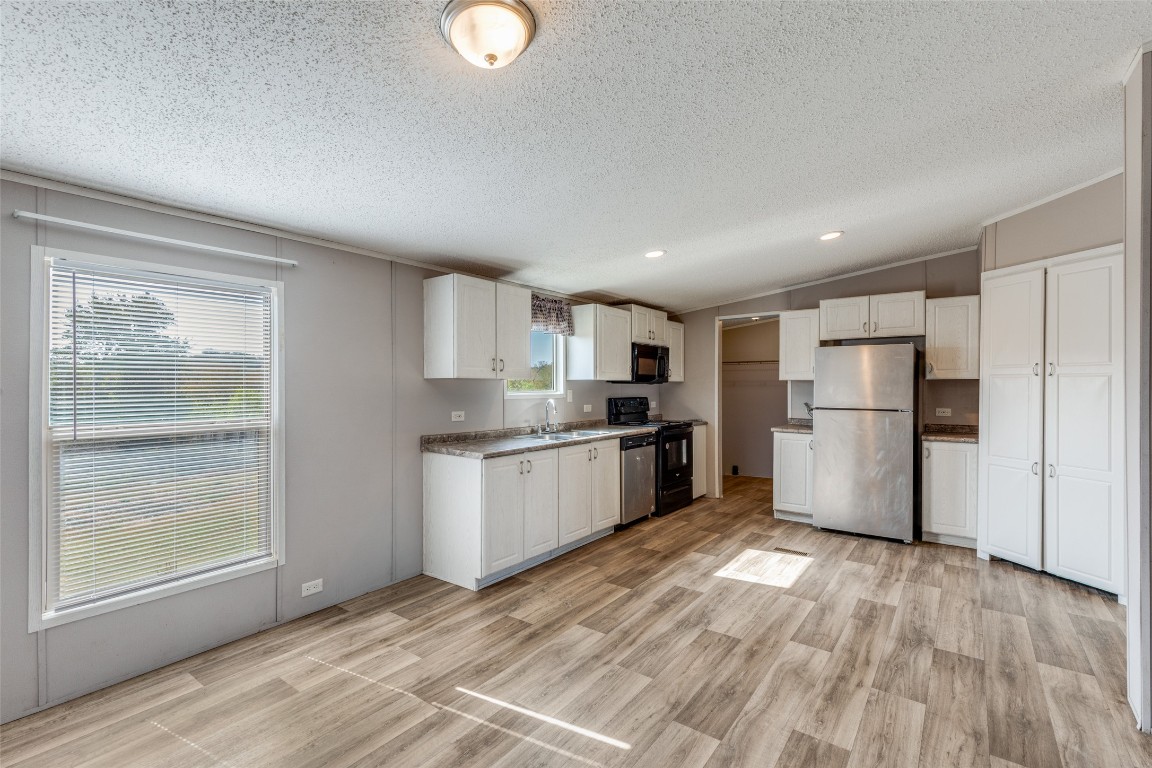 346 Rancho Linda Drive Lockhart, TX 78644 - Photo 9 of 25 a kitchen with granite countertop a refrigerator and a stove top oven
