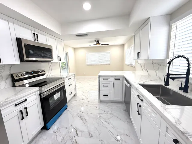 a kitchen with stainless steel appliances a stove sink microwave and cabinets