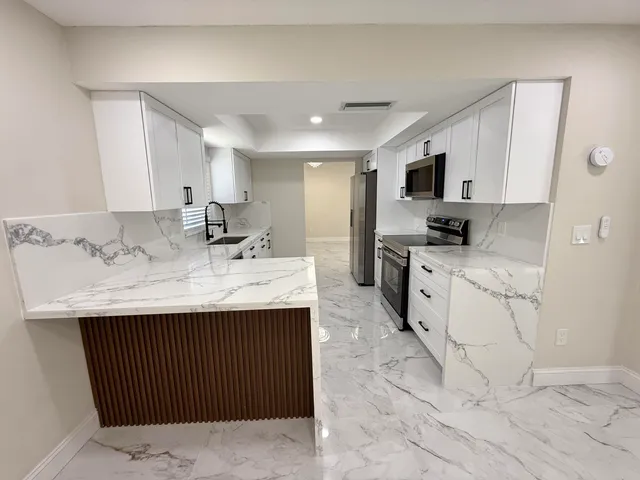 a kitchen with granite countertop a sink a stove and cabinets