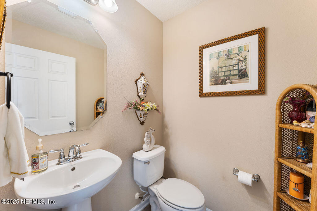 205 Islander Drive St. Augustine, FL 32080 - Photo 30 of 43 a bathroom with a toilet a sink and mirror