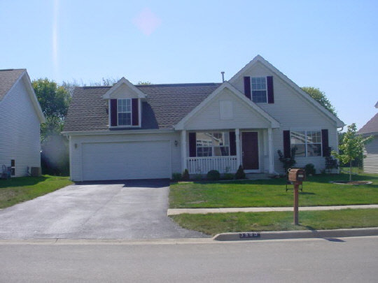 3963 Linden Road Rockford, IL 61109 - Photo 1 of 6 a front view of a house with a yard and garage