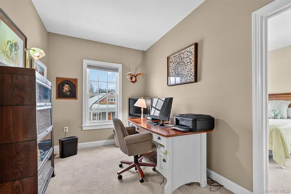 a view of a workspace with furniture and a window