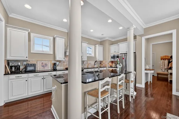 a kitchen with stainless steel appliances kitchen island granite countertop a refrigerator and cabinets