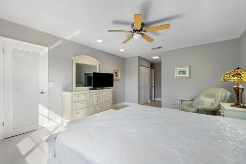 a bedroom with a bed a window and a television