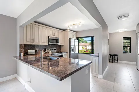 a kitchen with sink a microwave and cabinets