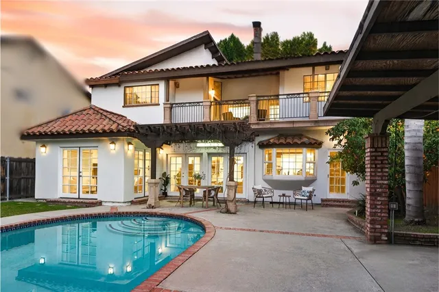 a front view of a house with swimming pool having outdoor seating